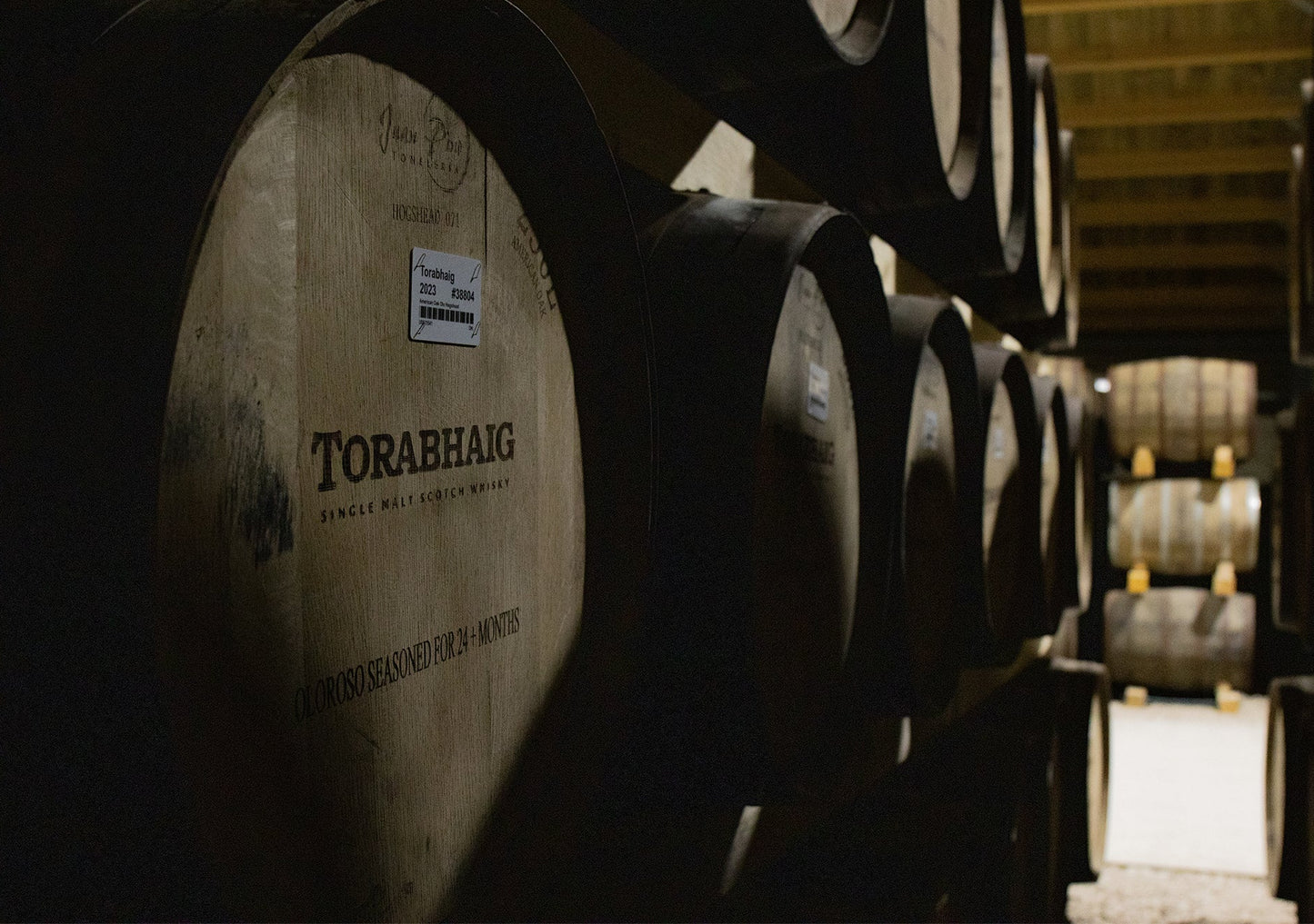 Torabhaig single malt whisky barrels stacked in a dimly lit warehouse